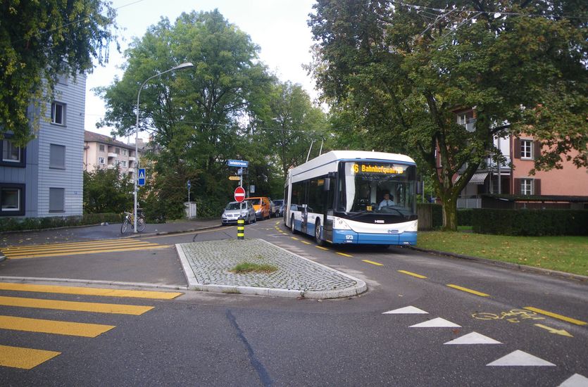 Strassenkreuzung in einem Wohnquartier mit Veloweg und Bus